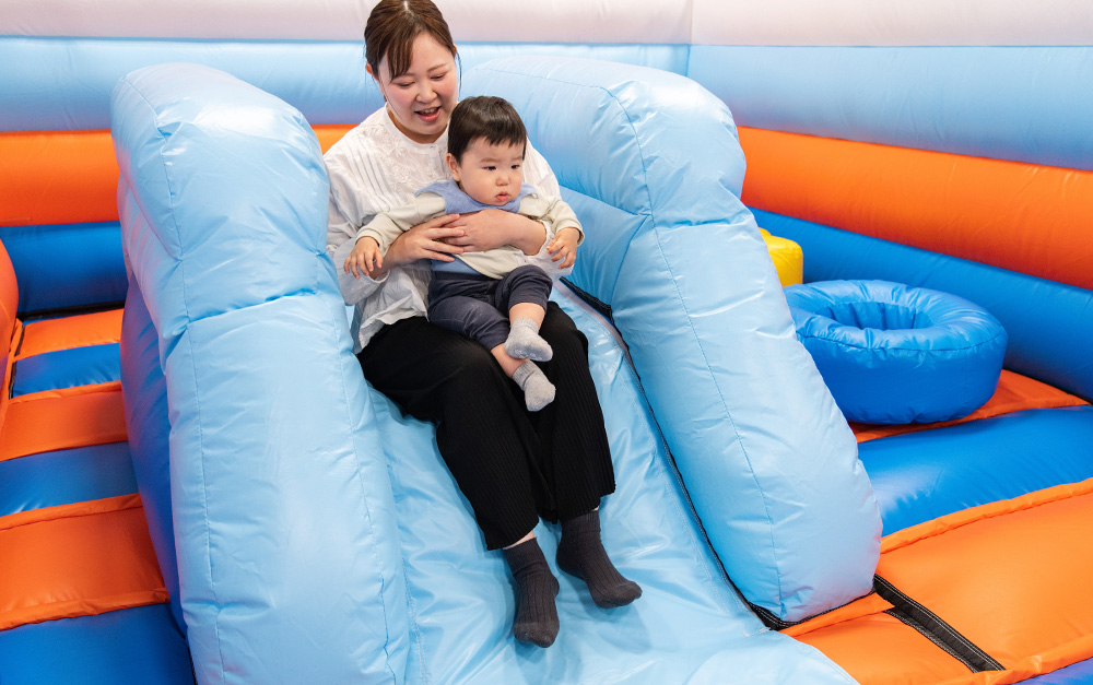 すべり台で遊ぶ親子